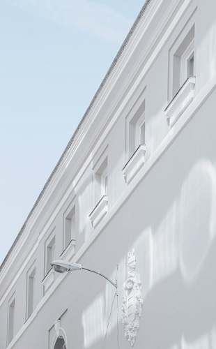 spain white street lamp mounted on white building wall corner
