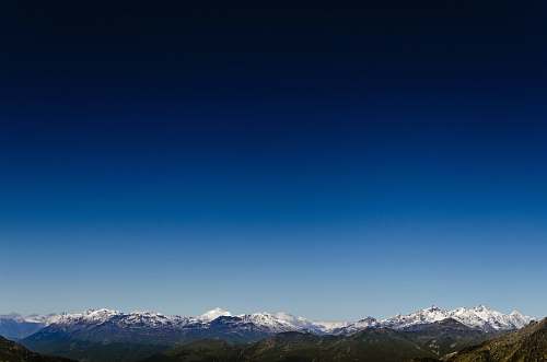 blue aerial photo of snow covered mountain sky