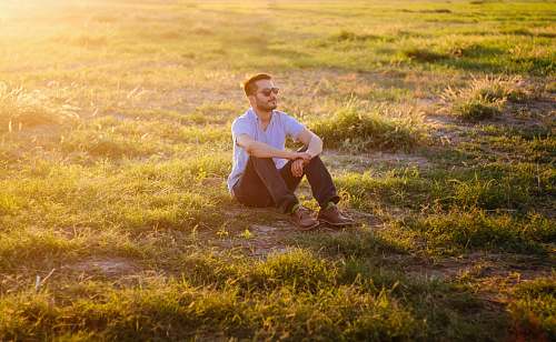 person man sitting on green grass field human