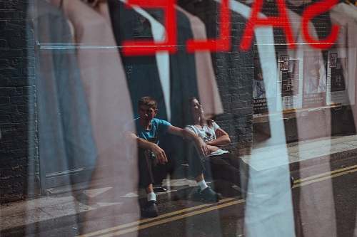 person two people sitting on sidewalk human