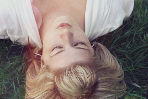 human woman lying on green grasses woman