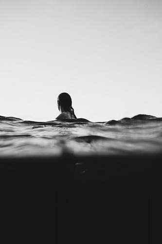human woman on body of water black-and-white