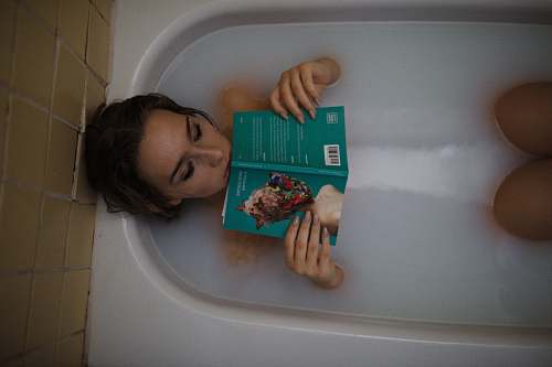 bathtub woman lying on bathtub with green book tub