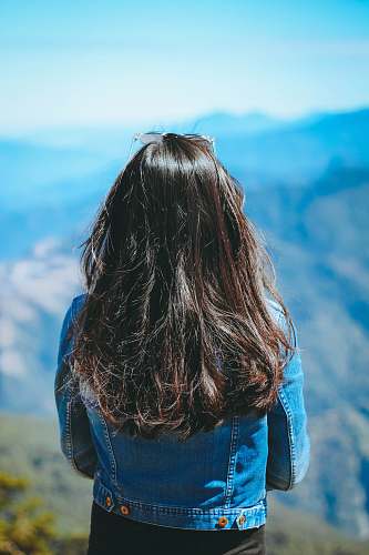 woman woman wearing blue denim jacket standing near mountain people