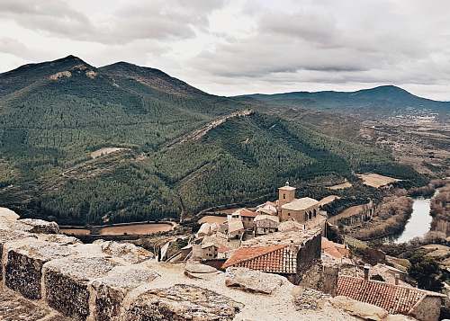 city aerial photography of brown buildings and green mountain during daytime town