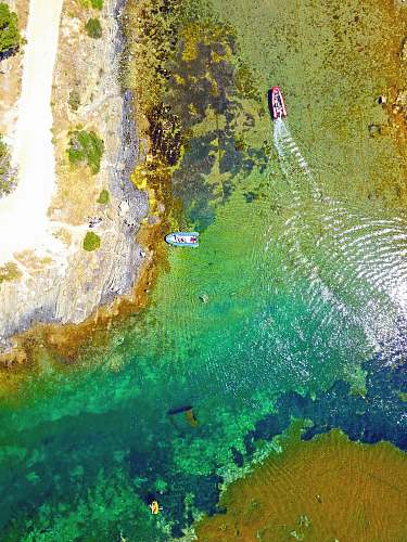bay aerial photography of red and blue boats aerial view