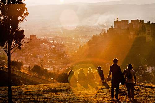 granada group of people sitting on grass field during daytime people