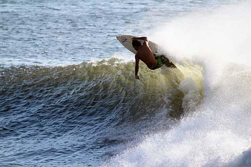 ocean man surfing with white wooden surfboard on sea sports