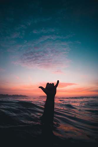 person person lifting his hand from water shaka
