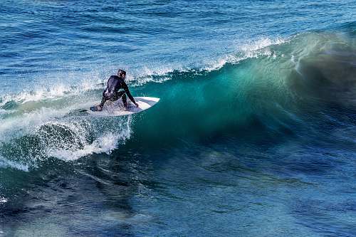 ocean person on white surfboard surrounded by blue ocean water during daytime sea