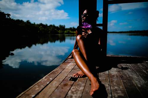 tan woman sitting near body of water lady