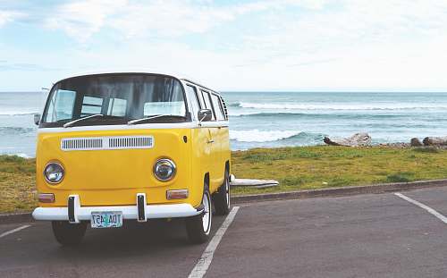 van yellow Volkswagen T2 van on concrete road seaside
