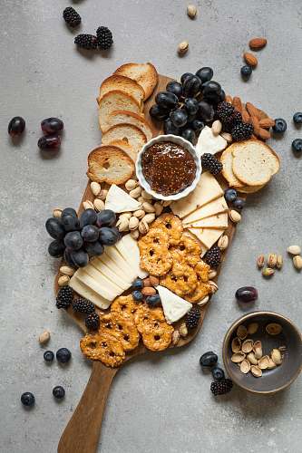 fruit baked breads and cookies on brown wooden board meal