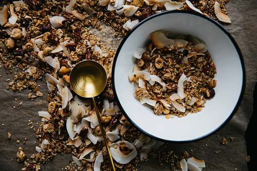 granola bowl beside brass-colored ladle seafood