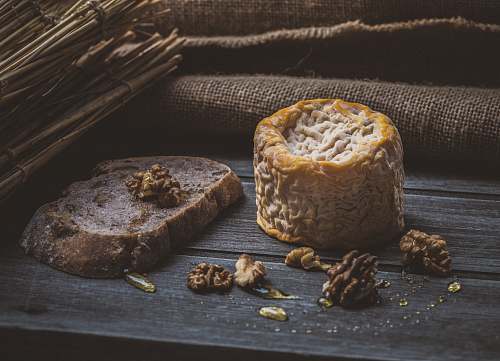 bread pine cones beside cheese on brown wooden plank seed