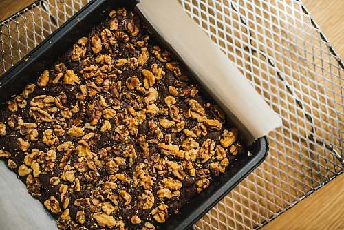 walnut square brown nut cake on black baking pan brownie