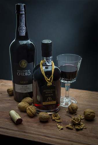 plant two liquor bottle beside wine glass on brown table glass