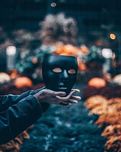 person person holding black mask mask