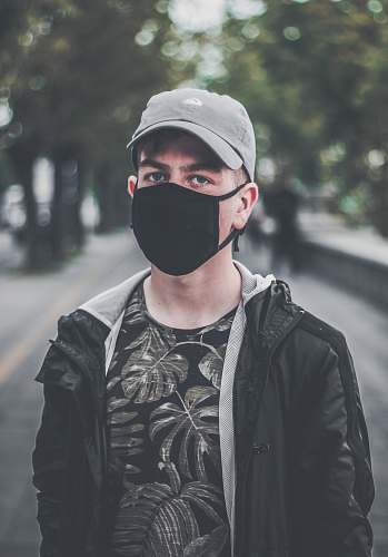 human man wearing black face mask on park during daytime person