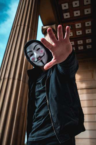 human man wearing Guy Fawkes Mask standing inside building person