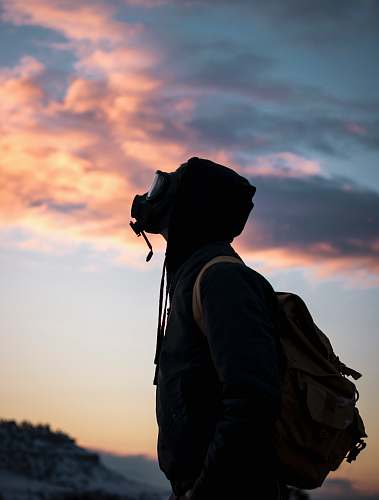 human person wearing gas mask while looking up person