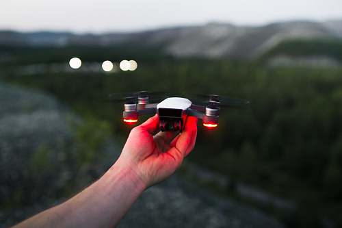 friends person holding black and red quadcopter smoke