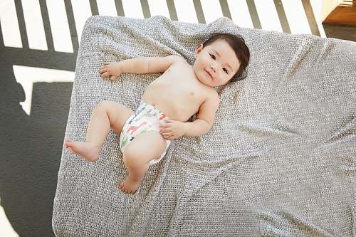 baby baby in a diaper on a gray bed newborn