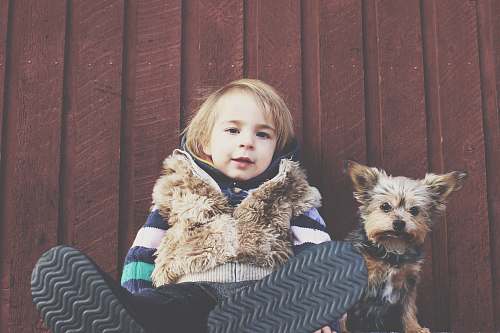 kid boy sitting on floor brside dog animal