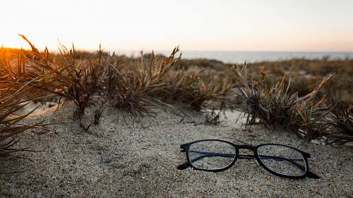 mexico clear eyeglasses with black frames on sand sun