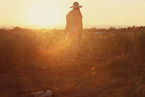 woman person standing on green grass during sunset light