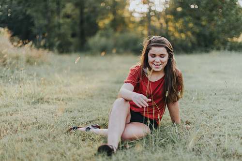 people selective focus photo of woman sitting on the grass girl