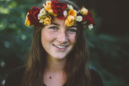 person selective focus photography of smiling woman wearing floral headdress flower