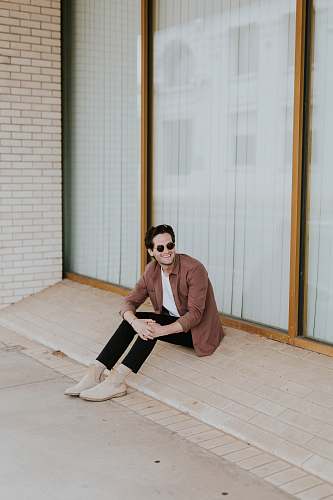 person smiling man sitting in door front flooring