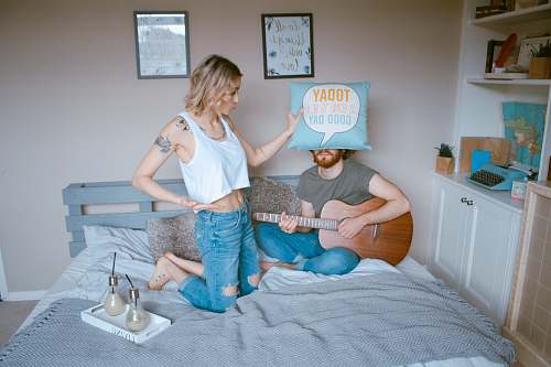 person woman and man on bed guitar