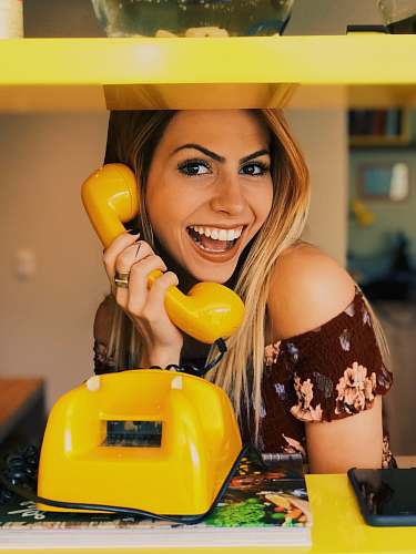 people woman holding yellow rotary telephone person
