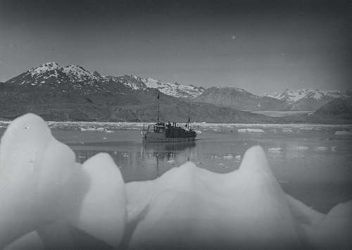 nature grayscale photo of boat near mountain grey