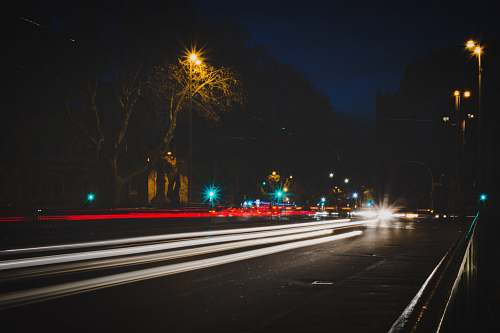 road time lapse photography of vehicle passing on road at night night