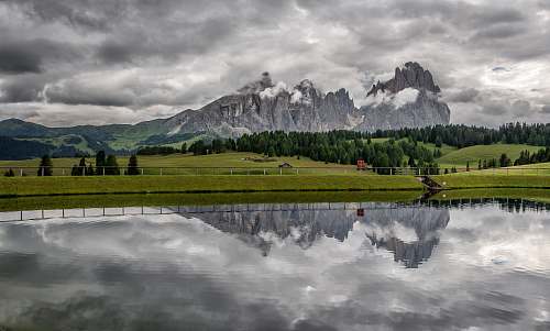 italy landscape photo of body of water near the field mountains