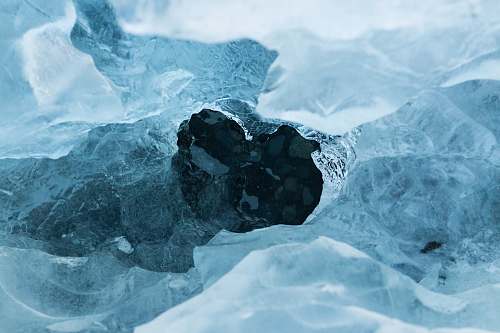 snow A hole in an ice sheet covering dark blue water ice