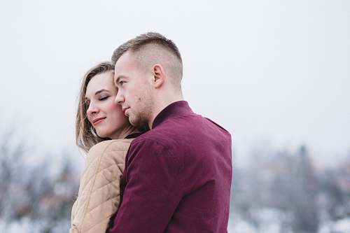 couple man hugging woman while standing on snowy weather caucasian