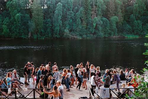 sweden people standing beside lake party