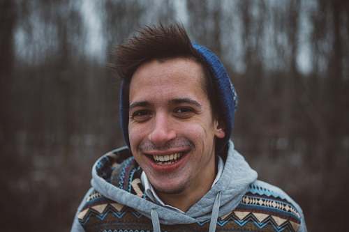 person shallow focus photography of a man smiling while taking picture human
