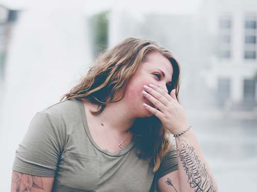 human woman covering her mouth person