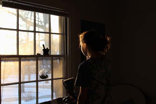 person woman in room facing window winter