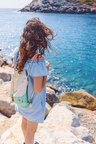 woman woman standing on brown rock near body of water person