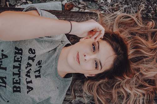 girl woman wearing gray t-shirt lying on ground portrait