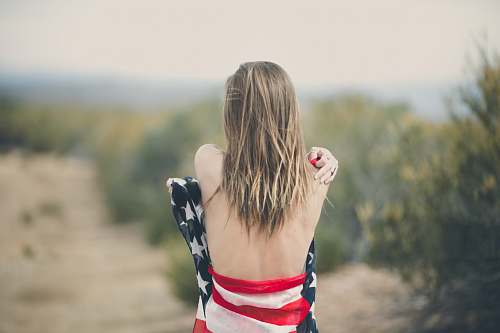 human focus photography of half naked woman covering body with USA flag woman