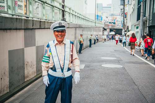 people man in white reflector suit standing near gray wall at daytime human