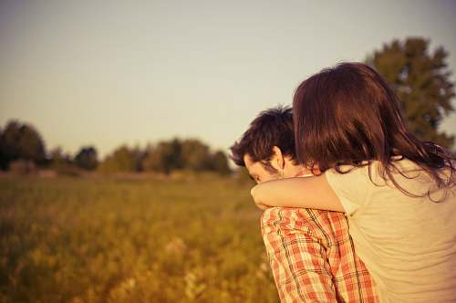 people person carrying woman walking on grass field hug