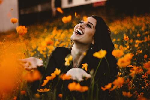 human woman laughing on flower field face